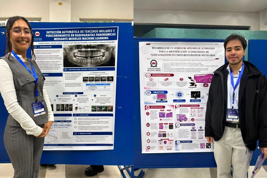 Two students stand beside large research posters at an indoor conference, smiling in front of blue display boards.